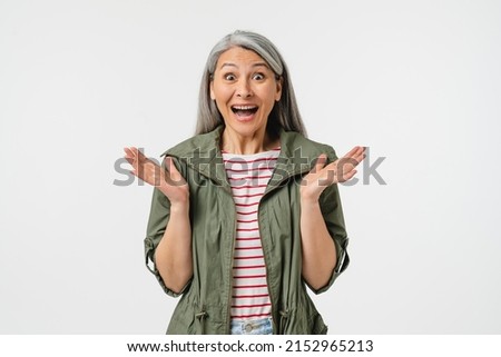 Extremely happy amused mature middle-aged caucasian woman in casual clothes and grey hair feeling shock impression, hearing good news, sale, discount, offer isolated in white background Royalty-Free Stock Photo #2152965213