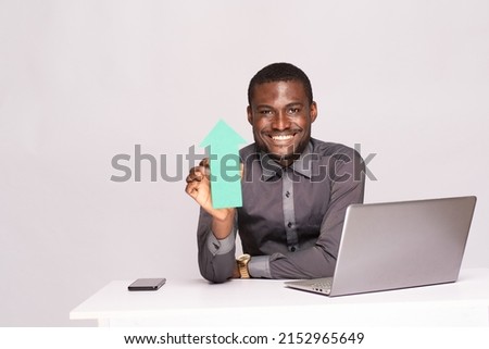 excited african businessman holding an arrow pointing upwards