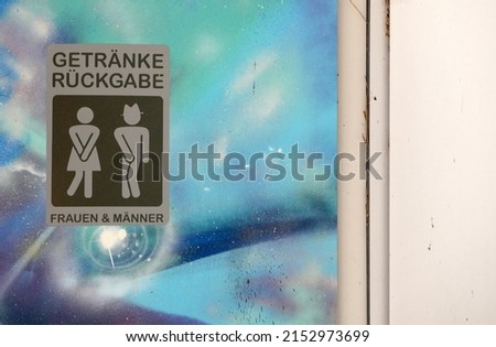 German unisex washroom door sign for "Frauen  Männer" (in Englisch "Woman  Men") with colorful painting stating "Getränke Rückgabe" (in English "drink return")