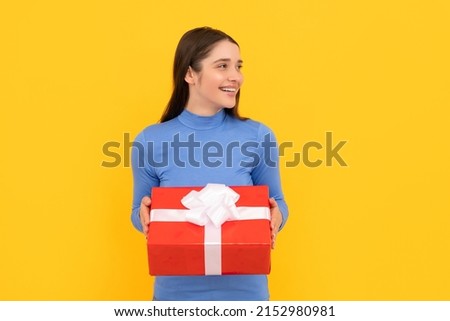 seasonal sales. smiling girl with box on yellow background. boxing day. present and gifts buy