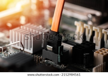 Close up orange Serial ATA(SATA) cable connected to computer motherboard. SATA is an interface for transferring data between a motherboard and mass storage devices. Royalty-Free Stock Photo #2152984561