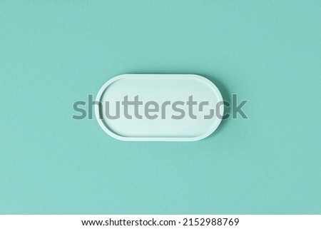 Podium for cosmetic product presentation. Abstract minimal geometrical form on blue background. Oval stone form. Scene, Showcase, display. Minimal design. Soft shadow. Flat lay, Top View. Copy space