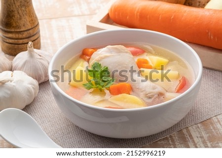 Clear chicken soup with potatoes carrot and onion in white bowl.Asian style food Royalty-Free Stock Photo #2152996219