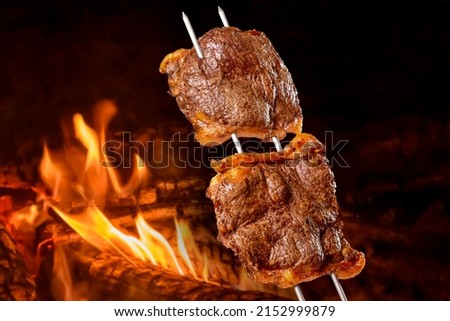 Picanha barbecue roasted on the spit on the coals. This type of barbecue is widely consumed throughout Brazil Royalty-Free Stock Photo #2152999879