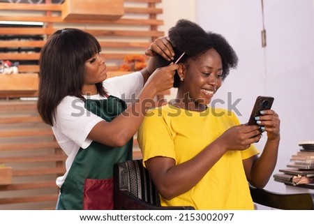 african lady checking her phone call while is being done Royalty-Free Stock Photo #2153002097