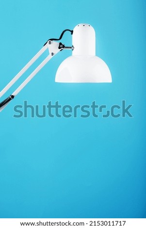 Office table lamp on blue background with space for text and idea concept