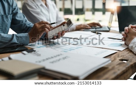 Accountant or bookkeeper working with calculator to calculate business data summary report, accountancy document and laptop computer at office, business meeting concept Royalty-Free Stock Photo #2153014133