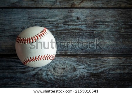 Leather baseball or softball ball on rustic wooden background with copy space.