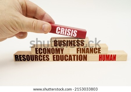 Business concept. On a white background, the hand adds blocks with inscriptions on a red block, the inscription - CRISIS