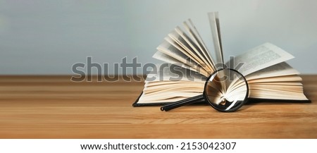 Banner with open book and magnifying glass. Information search and thorough analysis, research conducting concept. Copy space. High quality photo