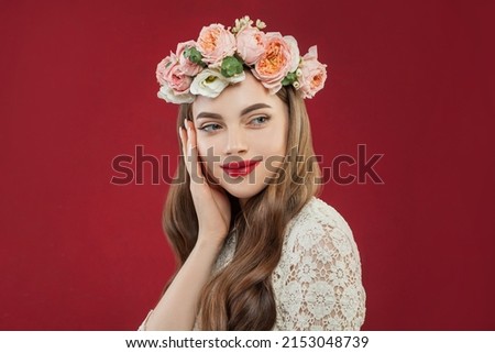 Spring portrait of beauty woman with flowers in studio on red background