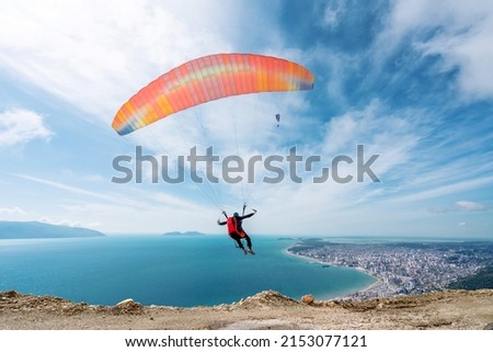 Paraglider is starting. Parachute is filling with air in the mountains alps on a sunny day in albania Royalty-Free Stock Photo #2153077121