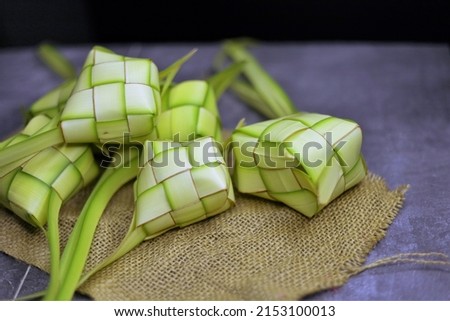 Steamed Rice cake packed inside a diamond-shaped container of woven palm leaf pouch or coconut leaves. Usually served on Special or Religious Feast Isolated Photo 