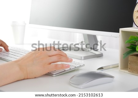 The hand of a woman operating a computer