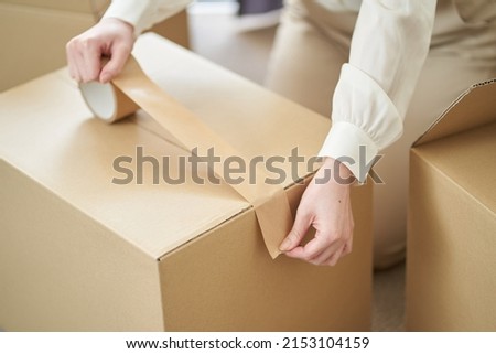 Asian woman sticking gum tape on cardboard Royalty-Free Stock Photo #2153104159