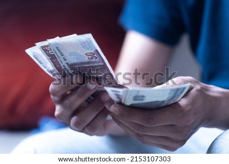 man holding and counting Egyptian currency  Royalty-Free Stock Photo #2153107303