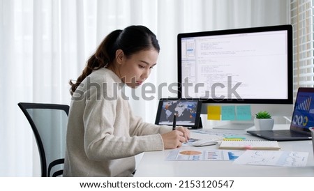 Asia young business woman sit busy at home office desk work code on desktop reskill upskill for job career remote self test IT deep tech ai design skill online html text for cyber security workforce. Royalty-Free Stock Photo #2153120547