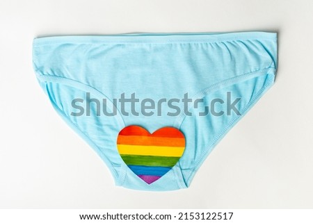 Blue women's panties and a rainbow heart shape as a symbol of women's health on a white background. Women's health concept. LGBT concept