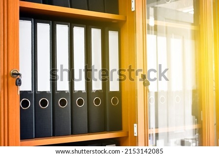An office binders cabinet that holds a large number of binders in an office, soft and selective focus on document binders. Royalty-Free Stock Photo #2153142085