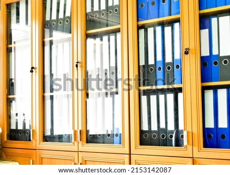 An office binders cabinet that holds a large number of binders in an office, soft and selective focus on document binders. Royalty-Free Stock Photo #2153142087