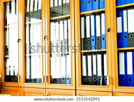 An office binders cabinet that holds a large number of binders in an office, soft and selective focus on document binders. Royalty-Free Stock Photo #2153142091