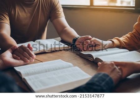 Christian family holding hands praying worship believe and seeking the blessings of God, fellowship, or bible study concept. They were reading the Bible and sharing the gospel. Royalty-Free Stock Photo #2153147877