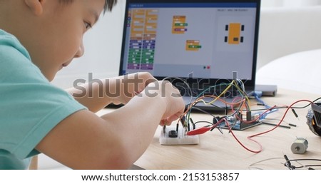 Asia home school young small kid happy smile self study online lesson excited make AI circuit toy. STEM STEAM digital scratch class on laptop screen for active children play arduino enjoy fun hobby. Royalty-Free Stock Photo #2153153857