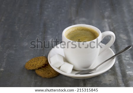 Cup of espresso with sugar cubes and cookies 