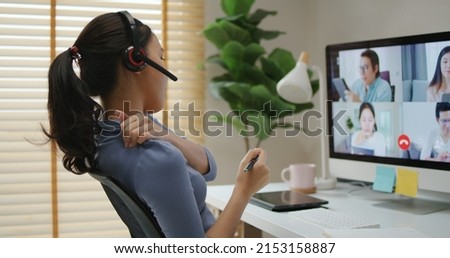 Young adult asia people busy work hard video call online group talk relief wrist pain carpal tunnel symptoms ache sit on desk chronic suffer burnout brownout office syndrome workforce impact at home. Royalty-Free Stock Photo #2153158887
