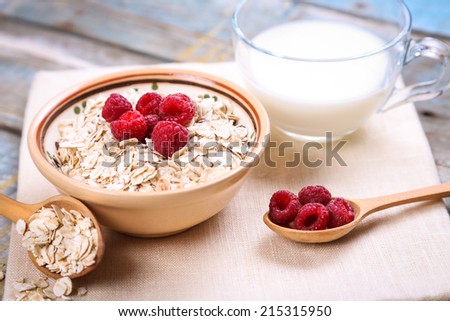oat flakes with raspberry in a bowl on textile Royalty-Free Stock Photo #215315950