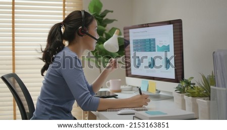 Asia people young casual woman remote work at desk home phone call talk study learn MBA online class. SEO sale plan report data chart graph on desktop PC screen reskill upskill career job workforce. Royalty-Free Stock Photo #2153163851