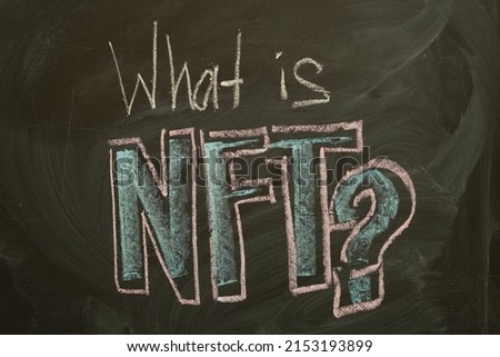 Inscription What is NFT? on a black board with chalk. Words WHAT IS NFT? written in chalk on a blackboard.