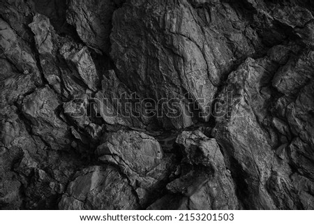   Black white rock texture. Rough mountain surface. Close-up. Dark volumetric stone background with space for design. Crumbled. Weathered.                              Royalty-Free Stock Photo #2153201503