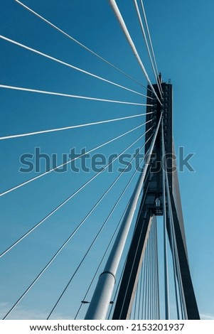 Bridge support with cables on sky background.