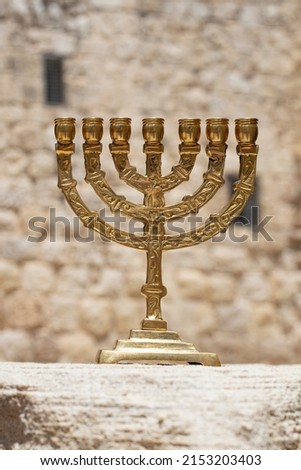 A gold menorah with a background of the walls of Jerusalem Royalty-Free Stock Photo #2153203403