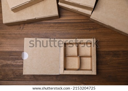 Open empty packaging box on wooden table, flat lay. Production line