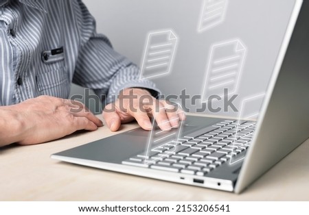 Businessman using laptop for electronic documents, letters sending and receiving. Man sitting at desk with computer. Online communication and paper flow concept. High quality photo