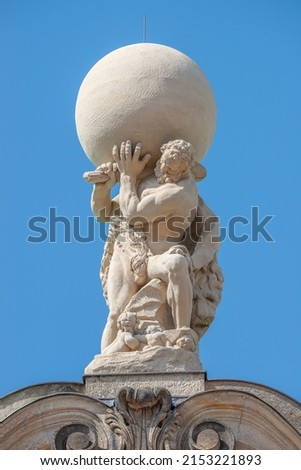 Old statue of powerful Heracles aka Atlas of Renaissance Era holding a globe, Earth at his shoulders in Dresden historical downtown at blue sky background, Germany Royalty-Free Stock Photo #2153221893