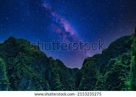 A night at Ko Hong, Krabi, Thailand with a beautiful starry night sky and dark green mountains.
