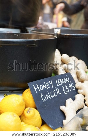Cast iron pots of honey, lemon and ginger hot drink on display at Borough Market in London. Image has copy space.