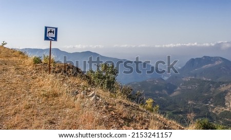 a water fountain signage on the mountain road ,drinking fountain signboard , blue plate, selective focus