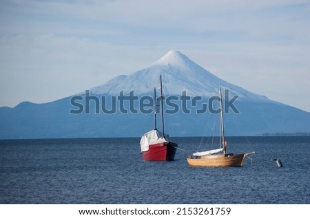 lago llanquihue in Puerto Varas, Chile with 2 boats and a beautiful snowy osorno volcano in the background
