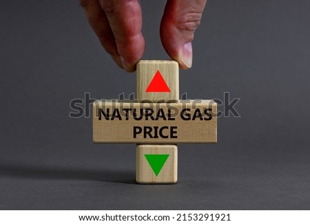 Symbol for increasing or decreasing price for natural gas. Businessman holds cube symbolizing Natural gas price level. Beautiful grey background. Business and natural gas price concept. Copy space.