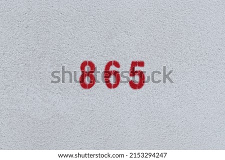 RED Number 865 on the white wall. Spray paint.
