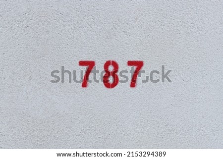 RED Number 787 on the white wall. Spray paint.
