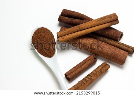 Cinnamon on a white background. Spoon ground cinnamon next to whole cinnamon. delicious spice