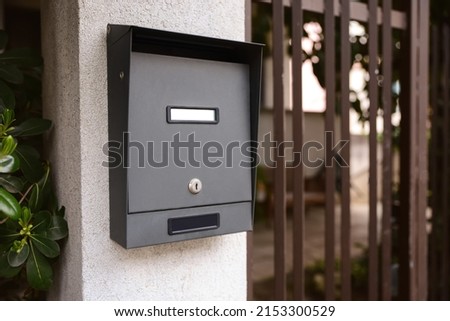 Black metal mailbox outdoors near entrance on spring day Royalty-Free Stock Photo #2153300529