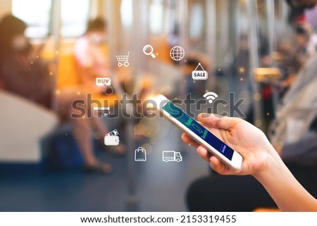 Woman shopping or paying online in application on smartphone while traveling on the subway train.