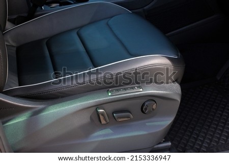 Detail of new modern car interior, Focus on seat adjust switch. The front passenger seat of a luxury business class car. Car seat manual adjust stick panel to control seat position in passenger car. Royalty-Free Stock Photo #2153336947