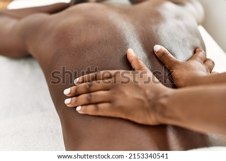 African american man reciving back massage at the clinic. Royalty-Free Stock Photo #2153340541